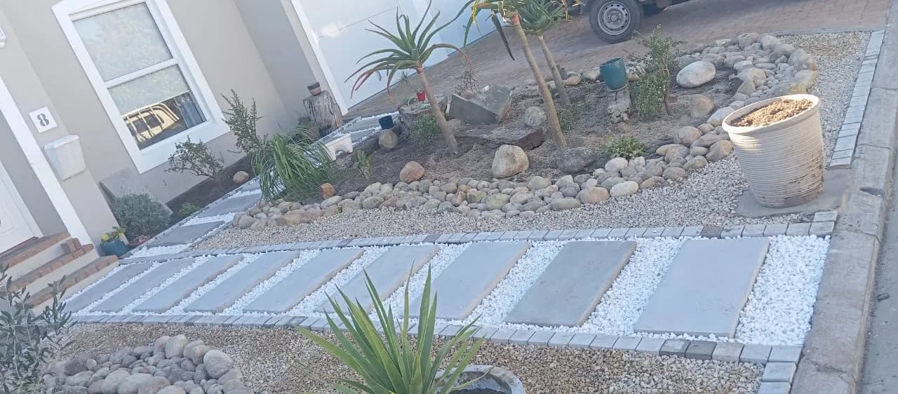 Stepping pavers in white pebbles with river-stone beds