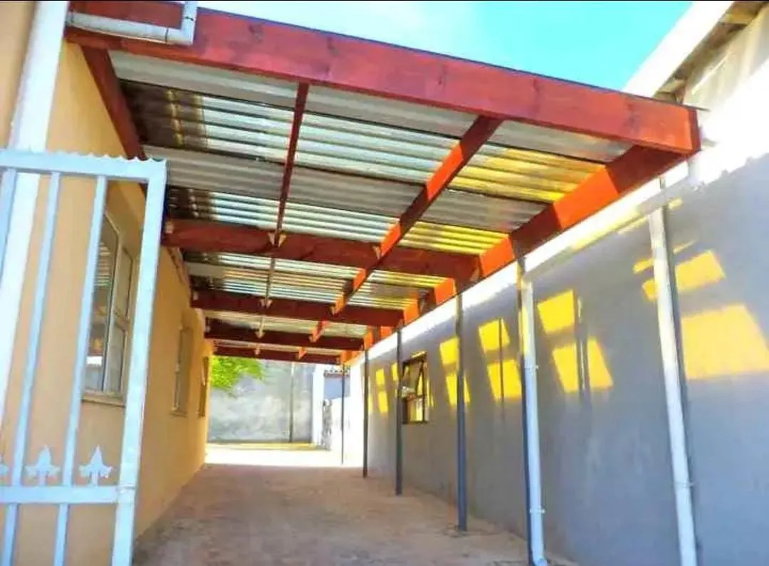 Timber pergola with translucent roof sheeting along a house
