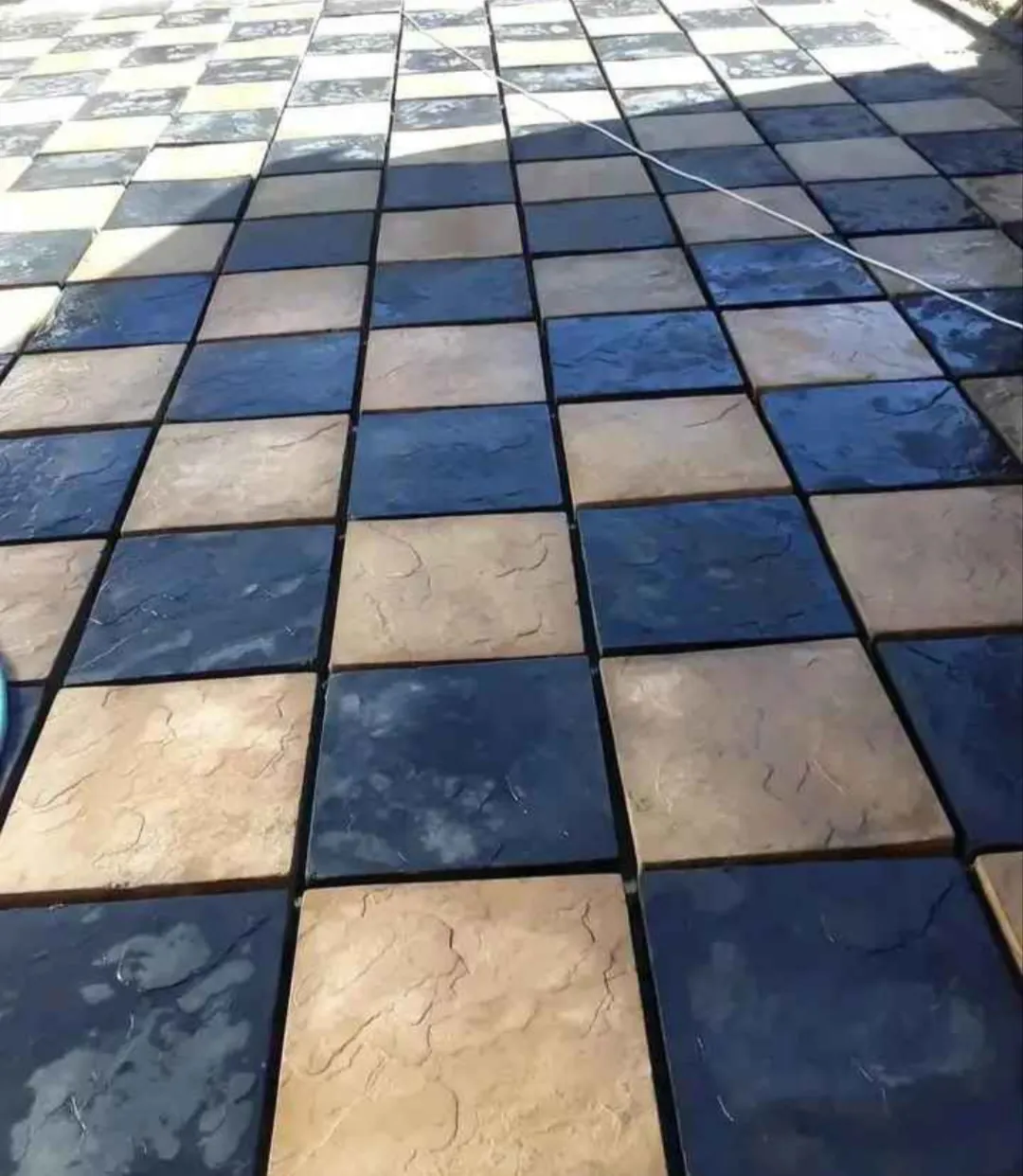 Checkerboard patio in charcoal and sandstone pavers