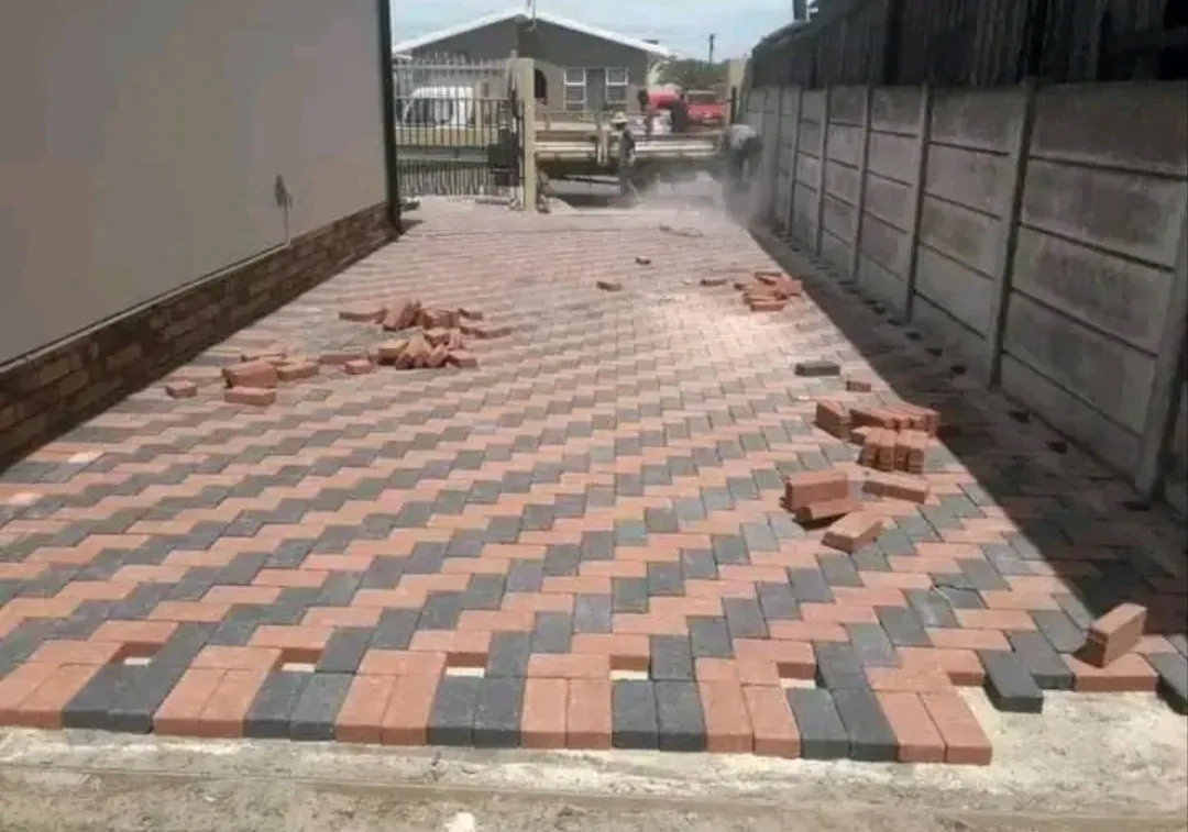 Two-tone herringbone paving being laid