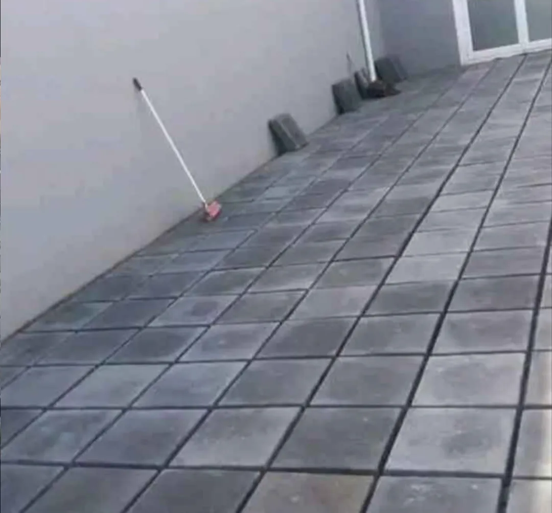 Charcoal square paving along a boundary wall