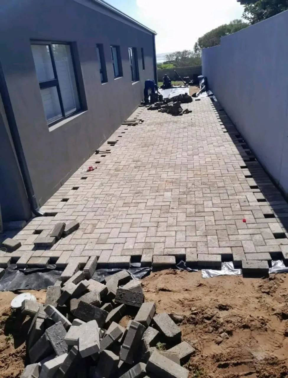 Grey paving being laid along a side passage